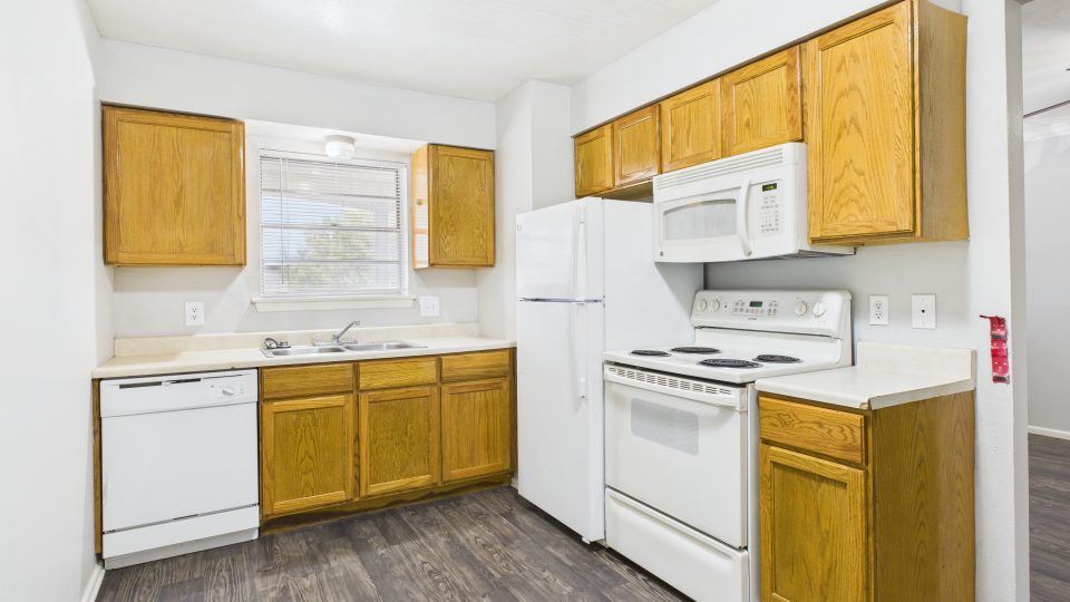 a kitchen with white cabinets and wood floors at The Cielo Vista